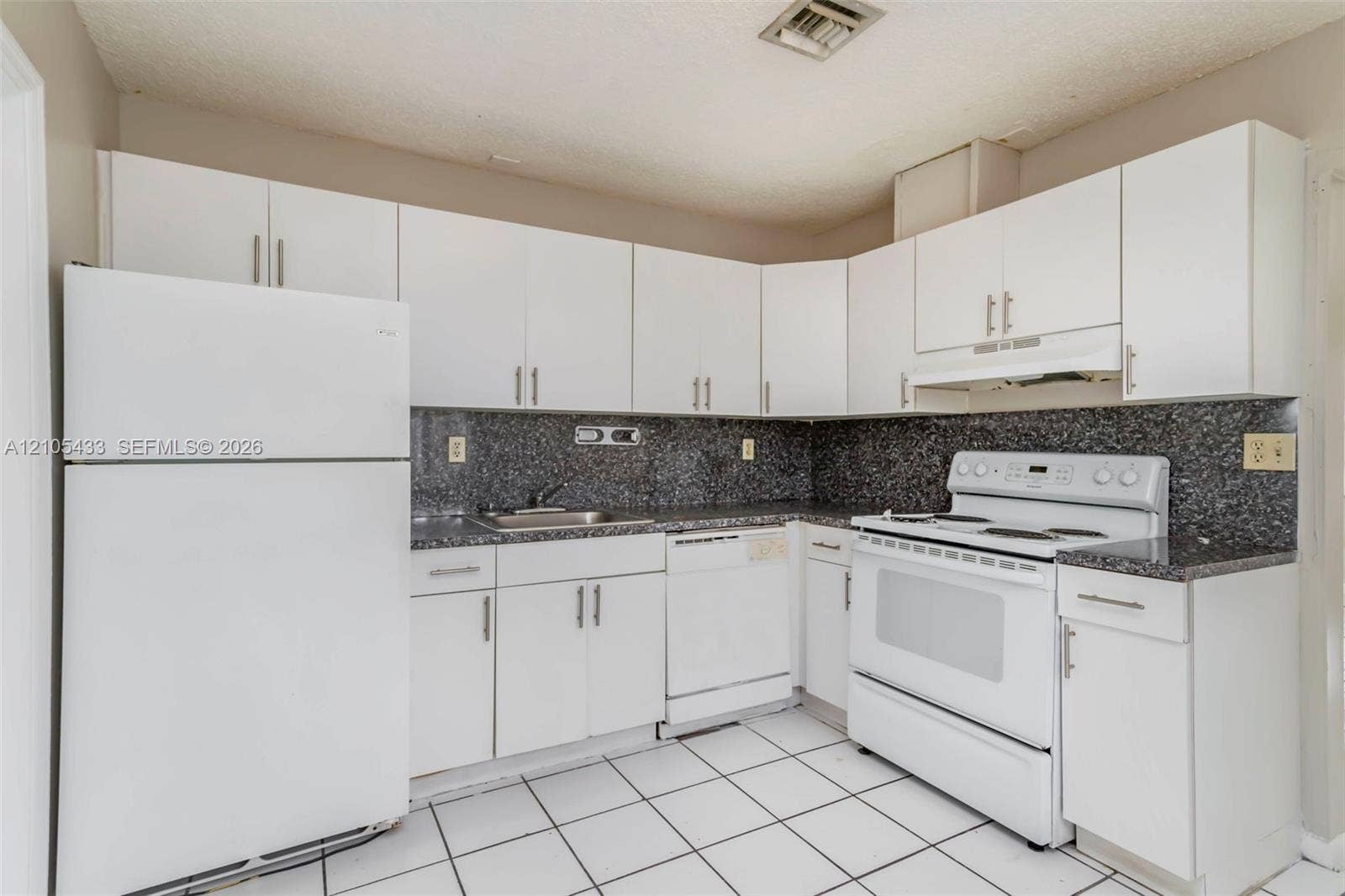 6331 Pierce Street, #1, Hollywood, Hollywood, FL 33024 White cabinetry, a full suite of white appliances, dark speckled countertops, and a tile backsplash
