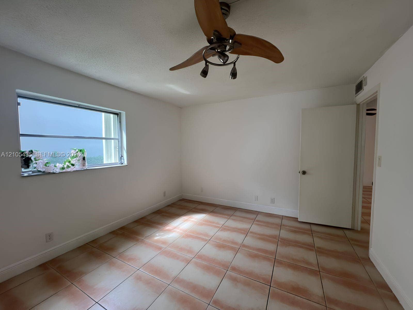 1428 SE 4th Avenue, #159, Deerfield Beach, FL 33441 Interior room featuring neutral wall finishes, tile flooring, a multi-pane horizontal window, and a ceiling fan with integrated lighting