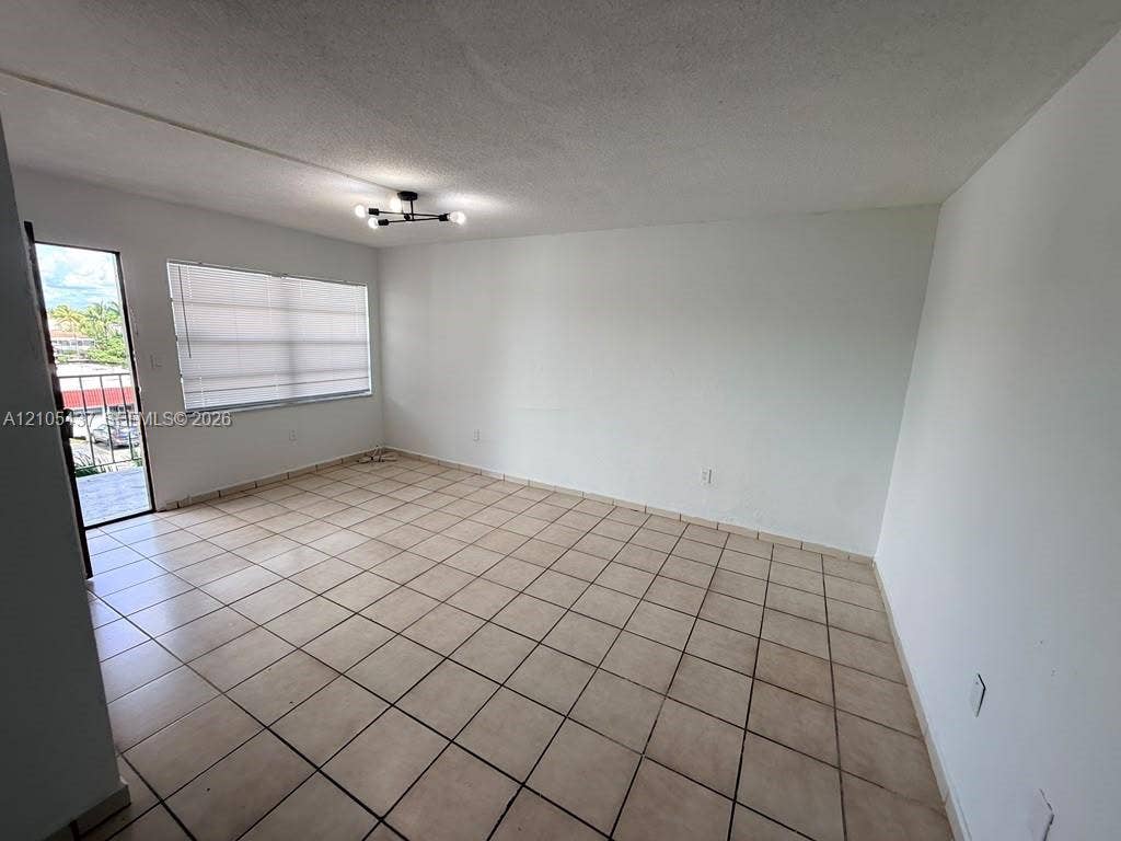 Tiled flooring throughout, neutral paint finishes, flush-mount lighting, and window with horizontal blinds