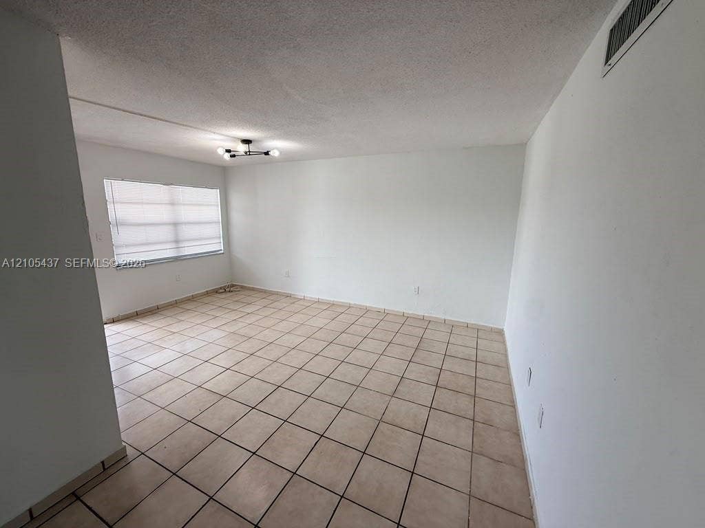 Recessed lighting, tile flooring, and neutral wall tones