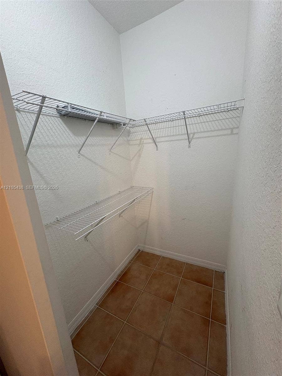 Built-in wire shelving, tiled flooring, and neutral wall finishes