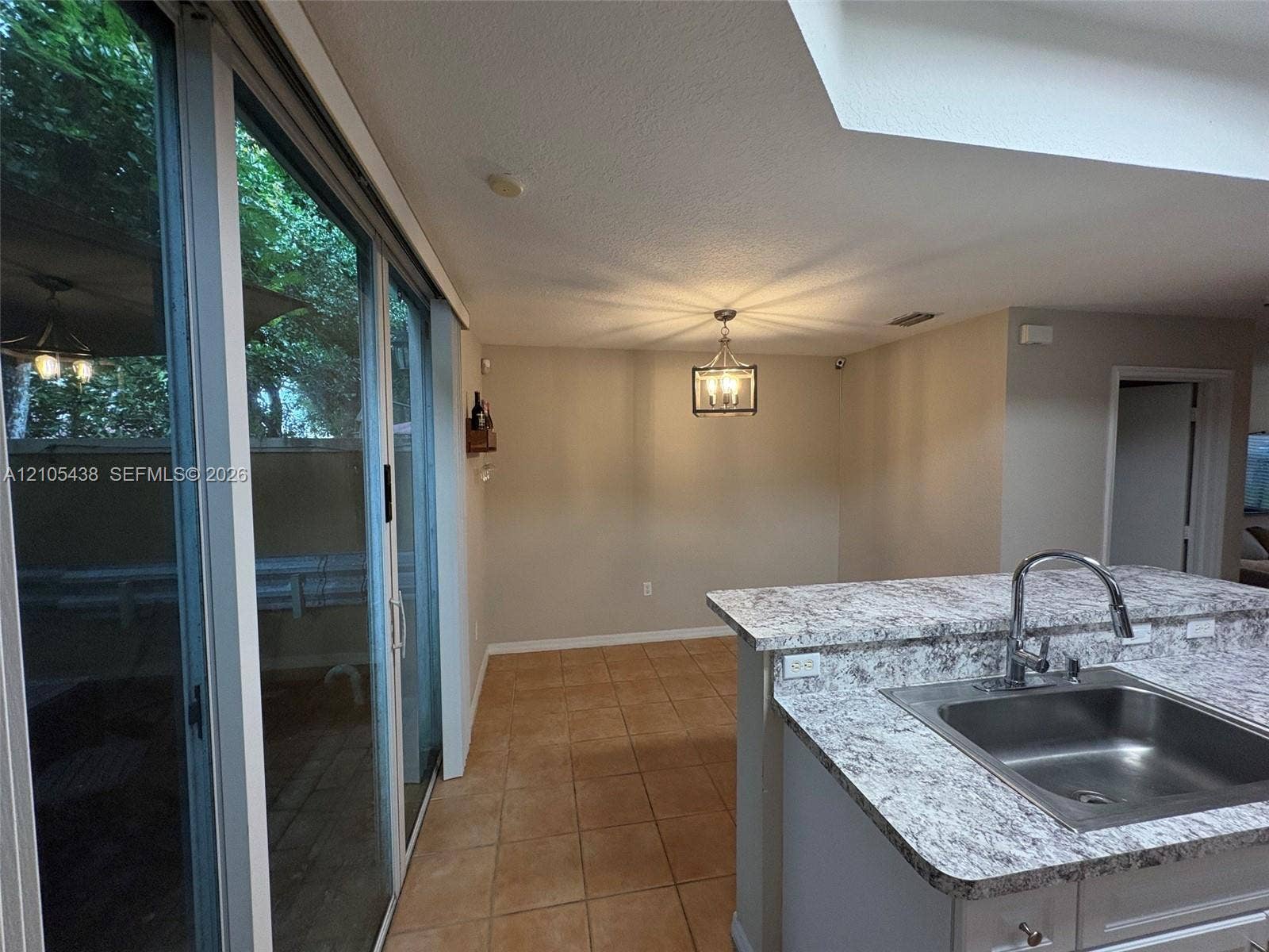 Kitchen island with an undermount sink, gooseneck faucet, and light-toned countertop