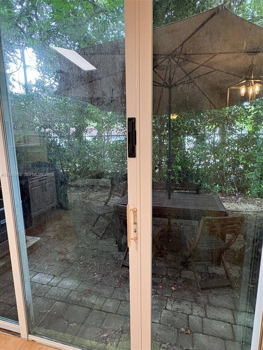 Sliding glass door leading to a brick paver patio