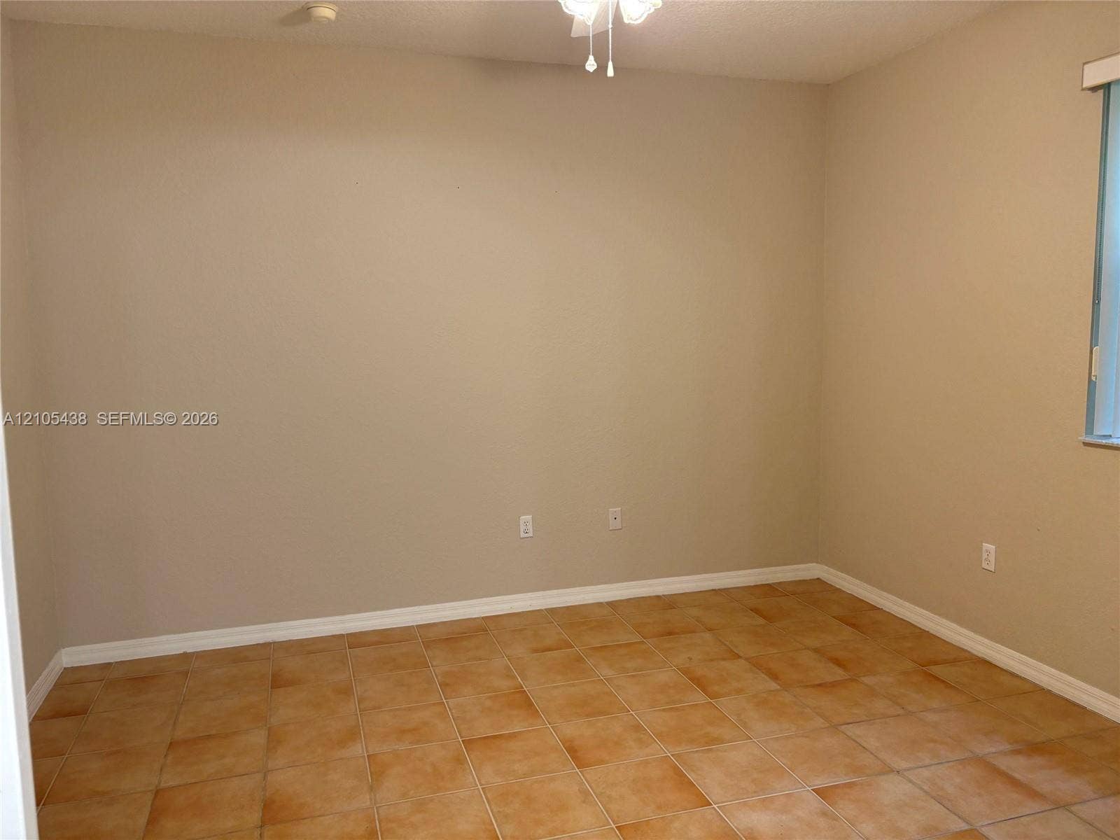 Neutral tone wall finishes, tiled flooring, white ceiling fan, and window with vertical blinds