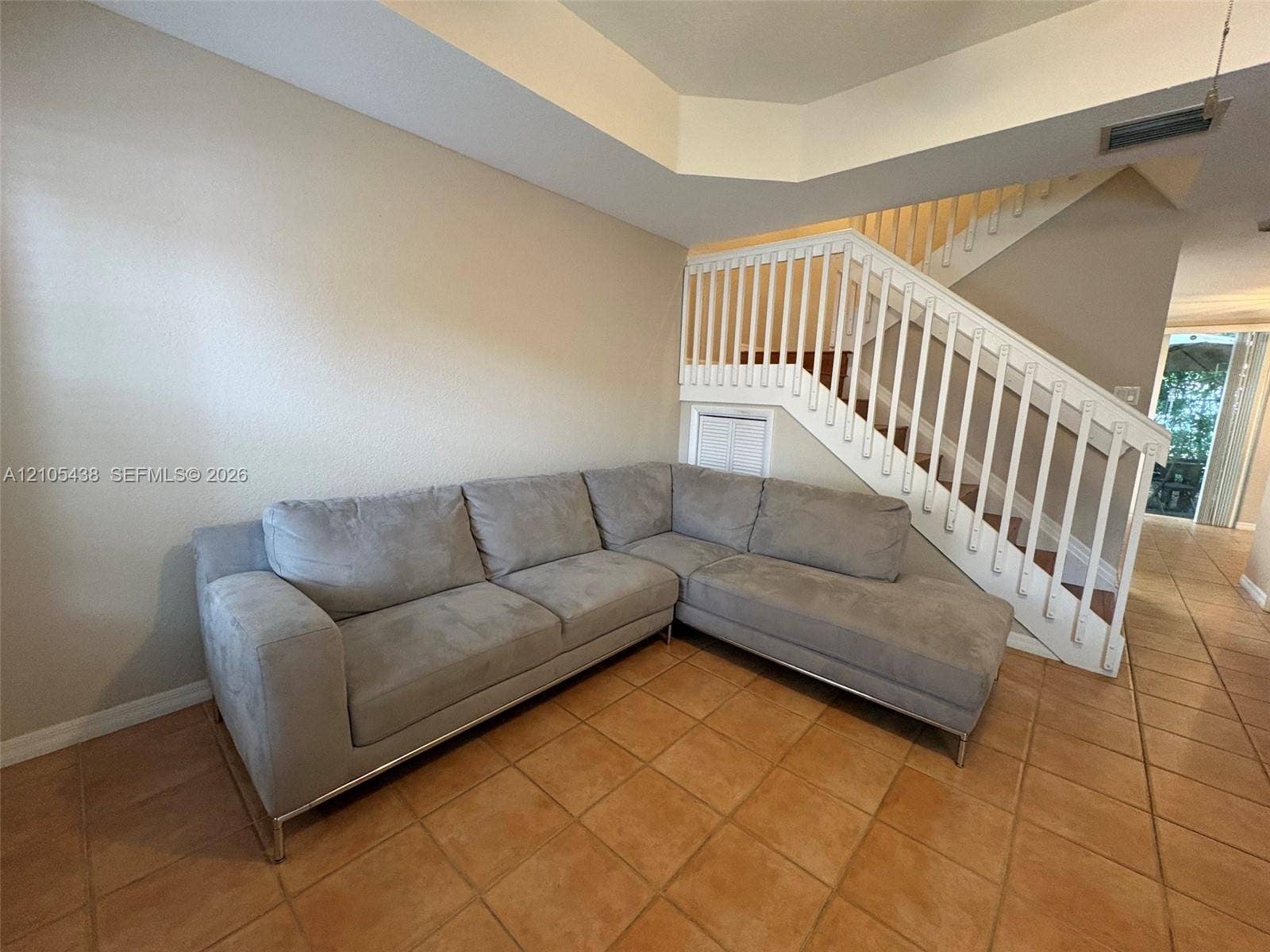 Staircase with white balusters and wood treads, accented by a built-in storage compartment