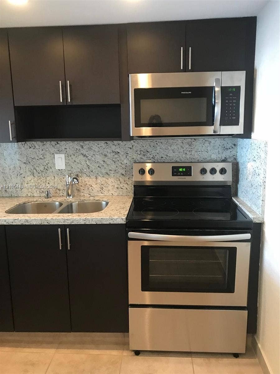 16710 NE 9th Avenue, #707, North Miami Beach, North Miami Beach, FL 33162 Granite countertops, stainless steel appliances, dark cabinetry with bar pulls, and a double basin sink