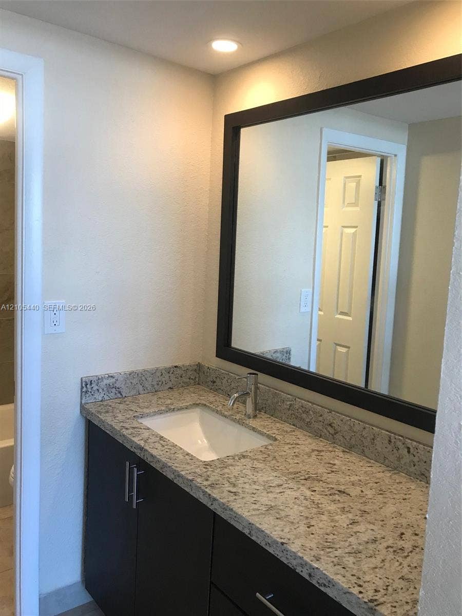 16710 NE 9th Avenue, #707, North Miami Beach, North Miami Beach, FL 33162 Recessed lighting, rectangular mirror with a dark frame, single basin sink, counter-mounted faucet, and dark wood-finish vanity with drawer pulls