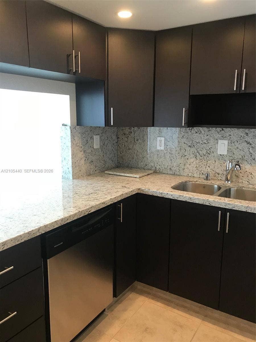 16710 NE 9th Avenue, #707, North Miami Beach, North Miami Beach, FL 33162 Modern kitchen featuring dark cabinetry, stainless steel dishwasher, double basin sink, and light-toned countertops with a matching backsplash