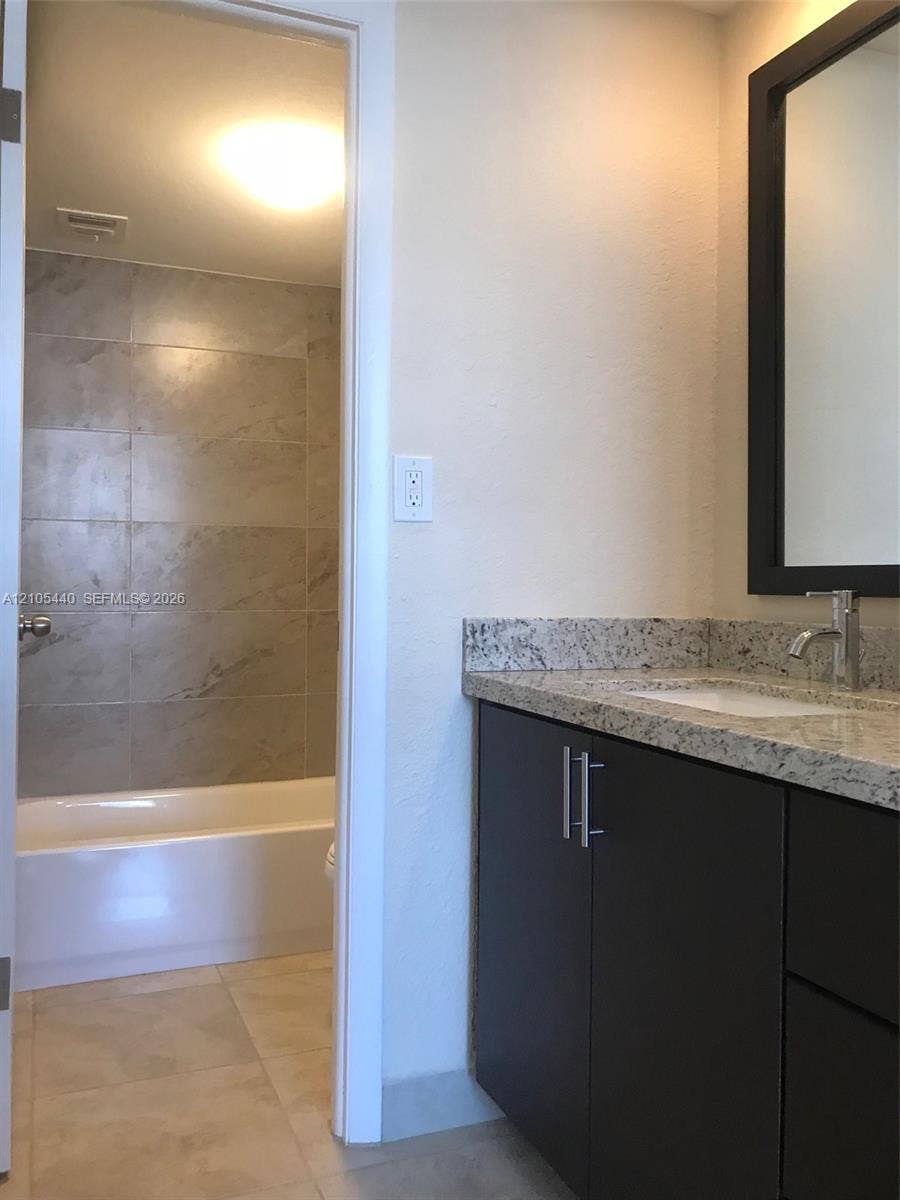16710 NE 9th Avenue, #707, North Miami Beach, North Miami Beach, FL 33162 Vanity with granite countertop, integrated sink, and dark cabinetry