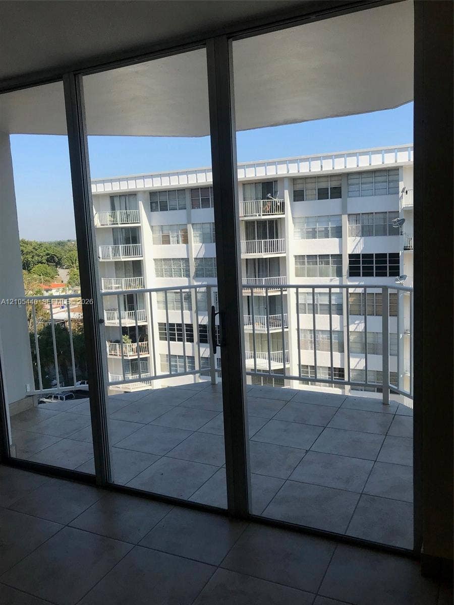 16710 NE 9th Avenue, #707, North Miami Beach, North Miami Beach, FL 33162 Expansive balcony with tile flooring and white metal railing, accessed through large sliding glass doors