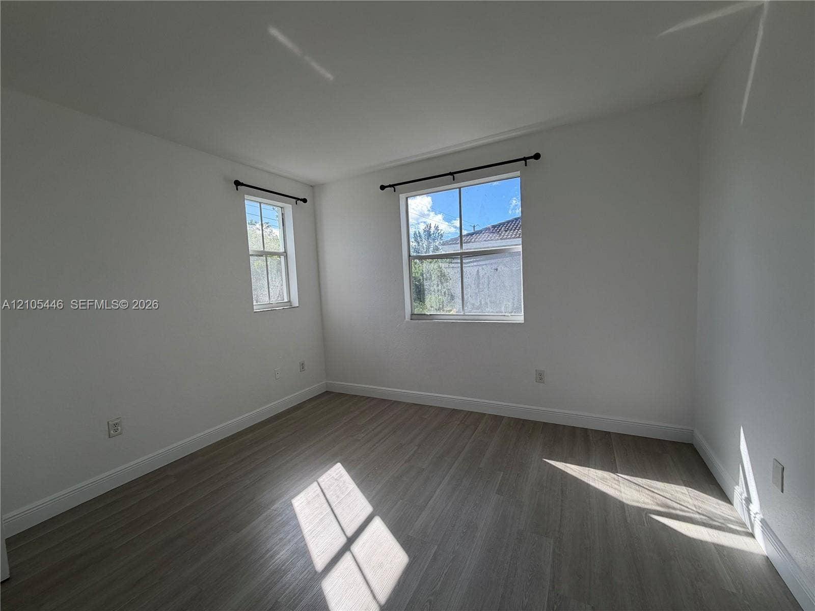 Neutral wall finishes, wood-finish flooring, and two windows