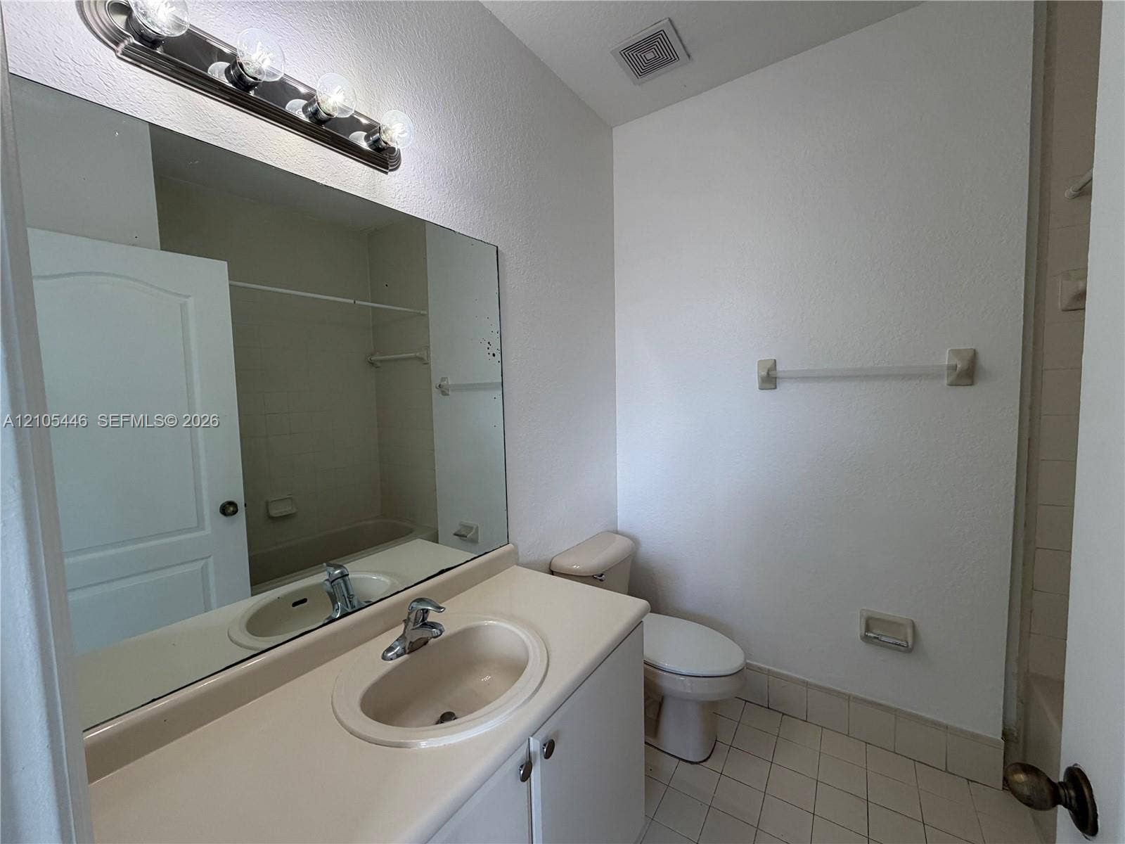 Vanity with integrated sink, chrome faucet, and expansive mirror