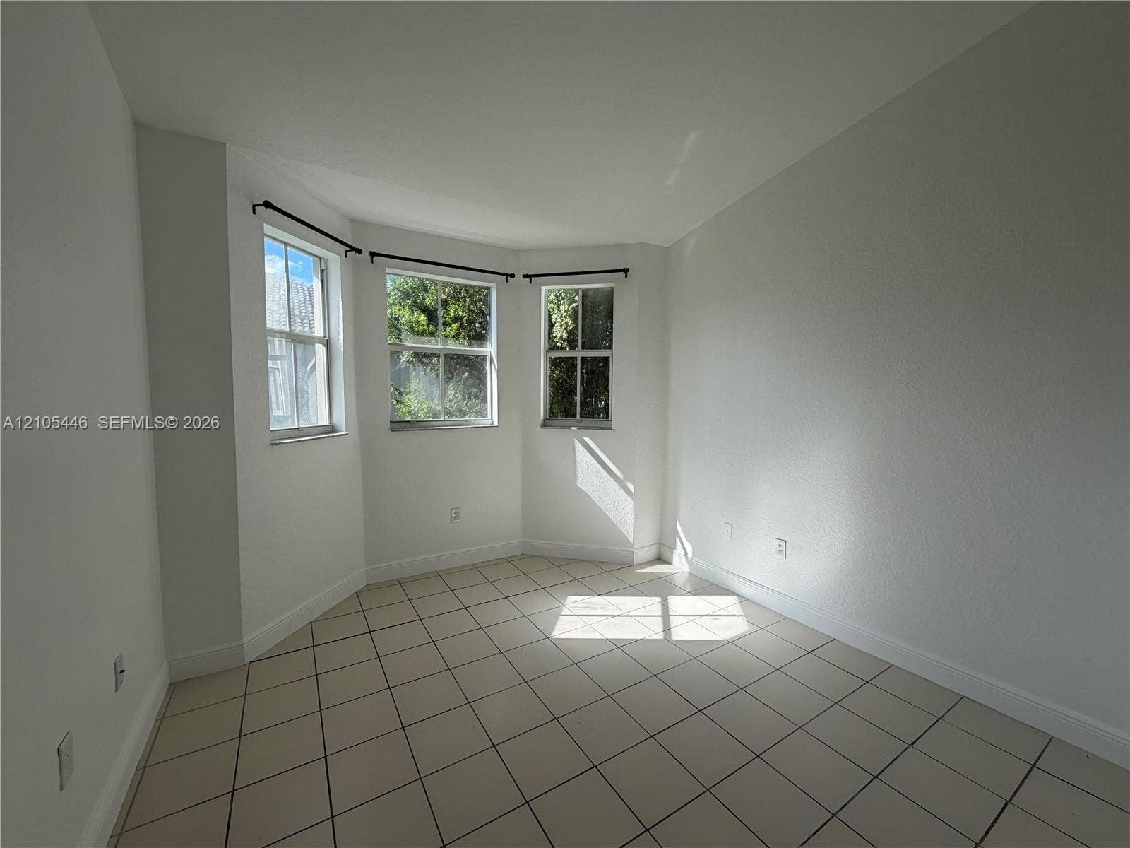Tile flooring, multiple windows, and white walls
