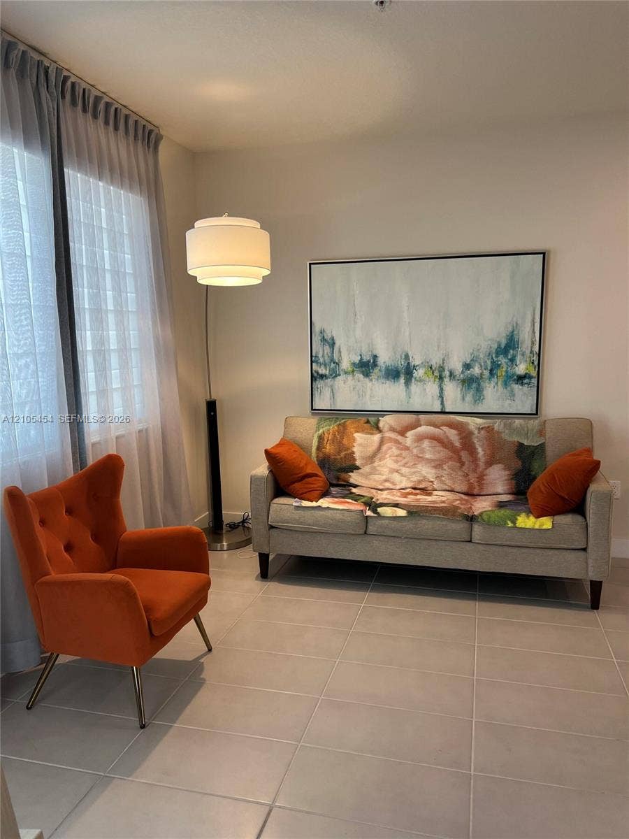 4745 NW 84th Court, #20, Doral, FL 33166 Light-colored wall finishes, full-height window with sheer drapes, recessed ceiling light, tile flooring, and a contemporary floor lamp