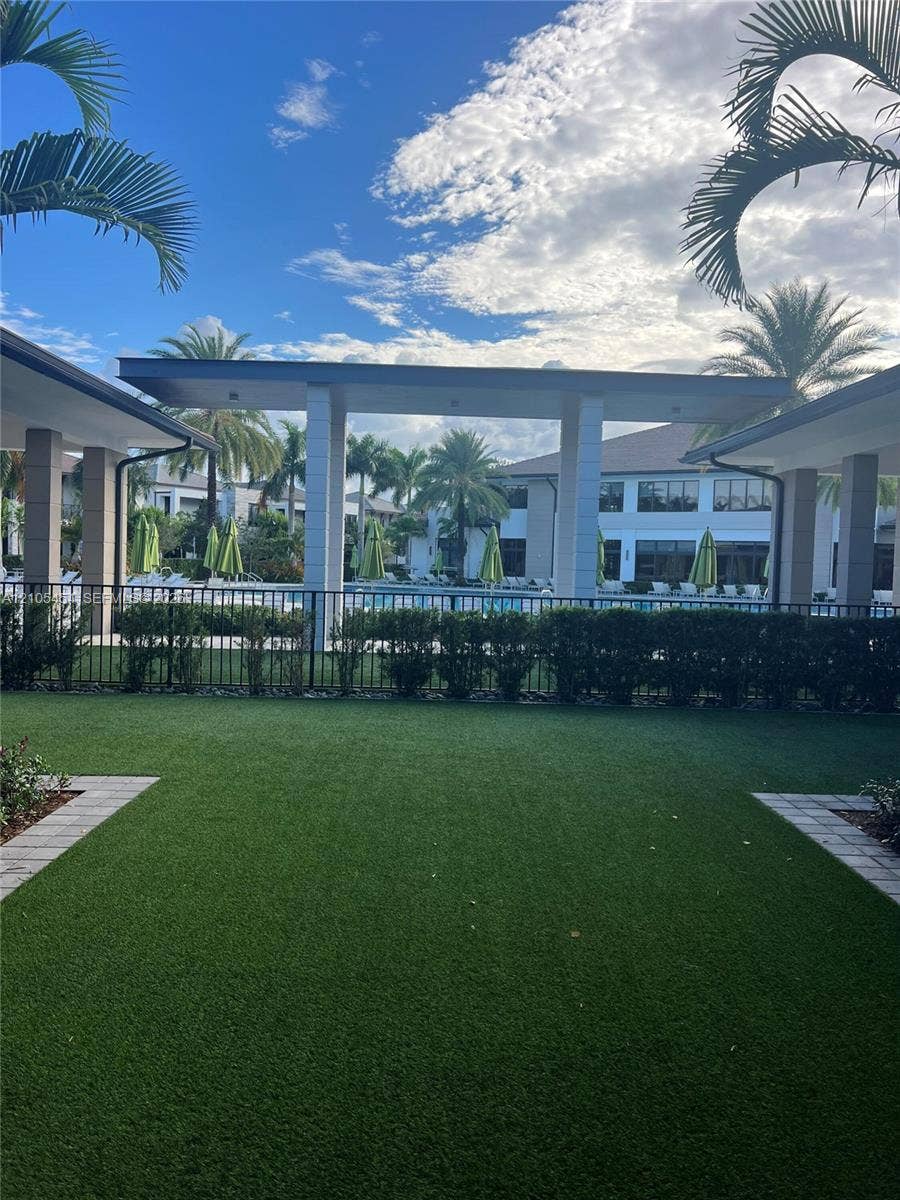 4745 NW 84th Court, #20, Doral, FL 33166 Expansive artificial turf lawn with paver stone borders and surrounding shrubbery