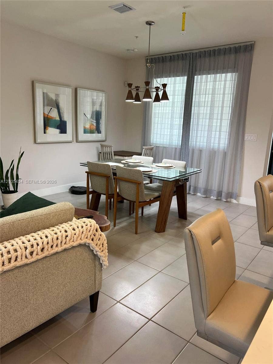 4745 NW 84th Court, #20, Doral, FL 33166 Recessed lighting, tiled flooring, and a modern chandelier illuminate the dining area