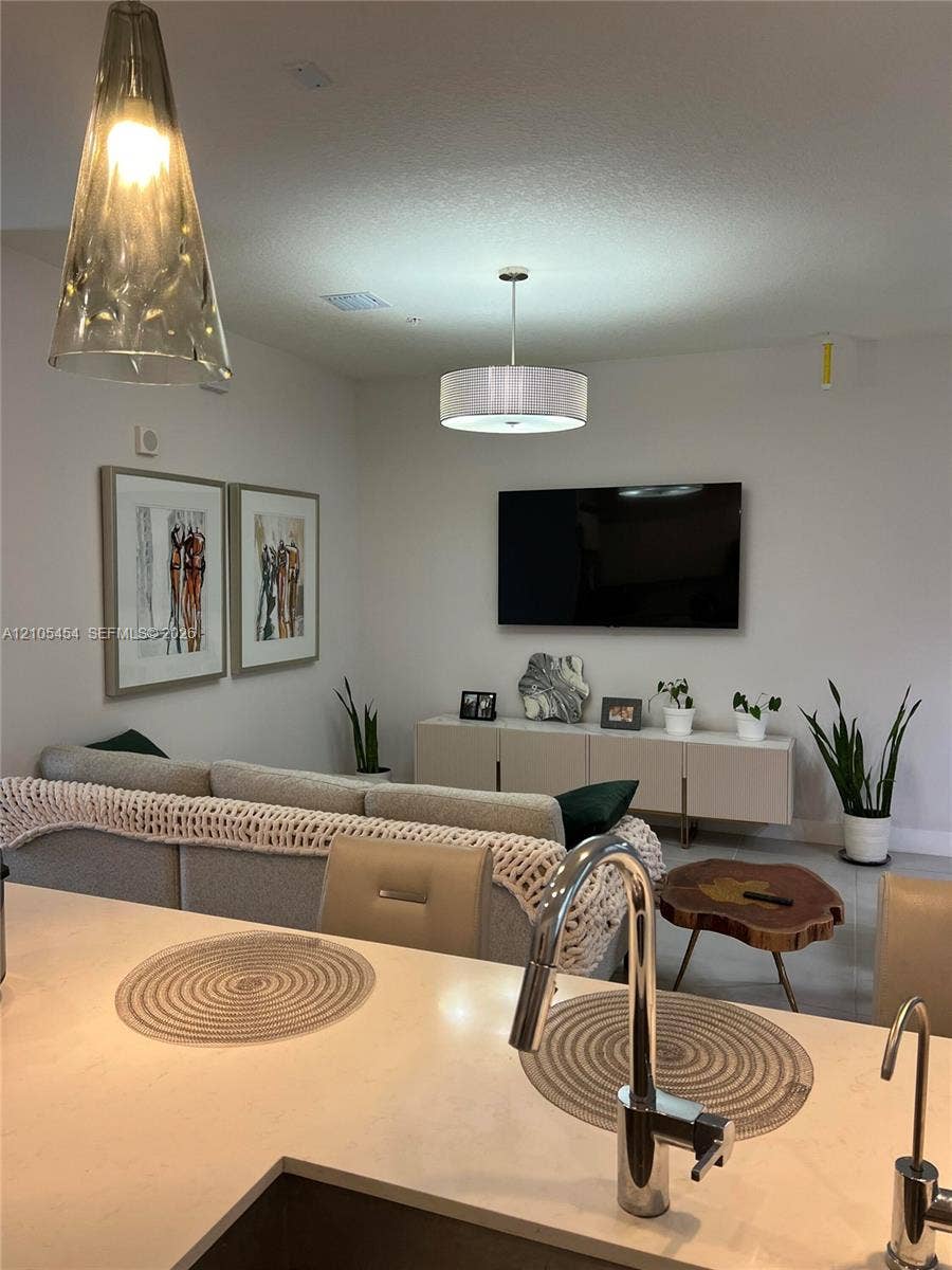 4745 NW 84th Court, #20, Doral, FL 33166 Integrated living space with a kitchen island, contemporary pendant lighting, recessed ceiling lights, wall-mounted television, and a built-in media console