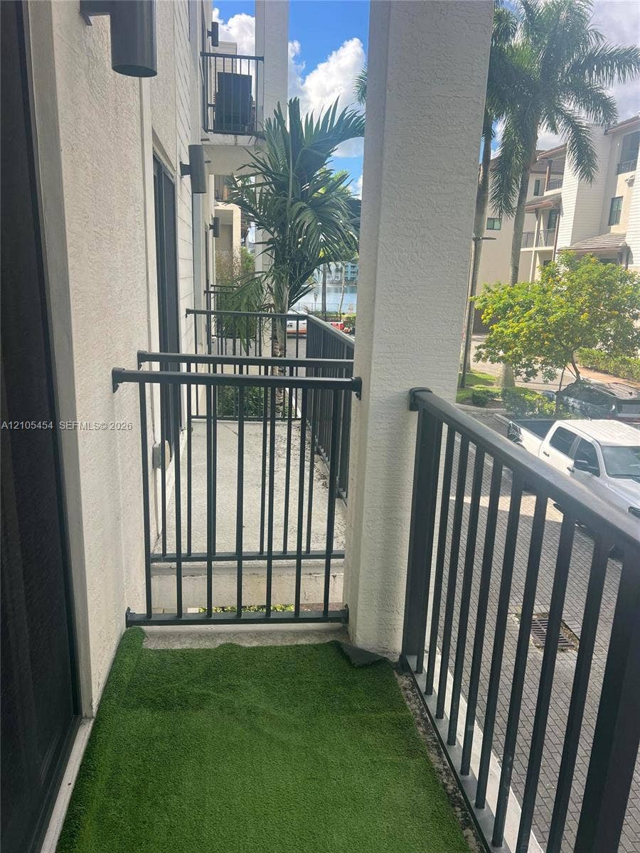 4745 NW 84th Court, #20, Doral, FL 33166 Balcony with metal railings, outdoor wall sconces, and a partial water scene