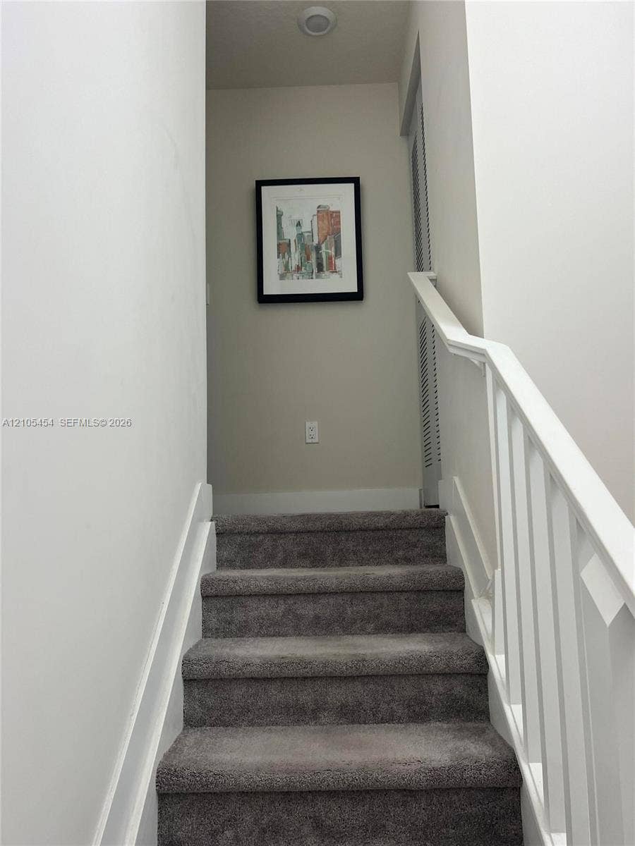4745 NW 84th Court, #20, Doral, FL 33166 Staircase with gray carpeting and white handrails