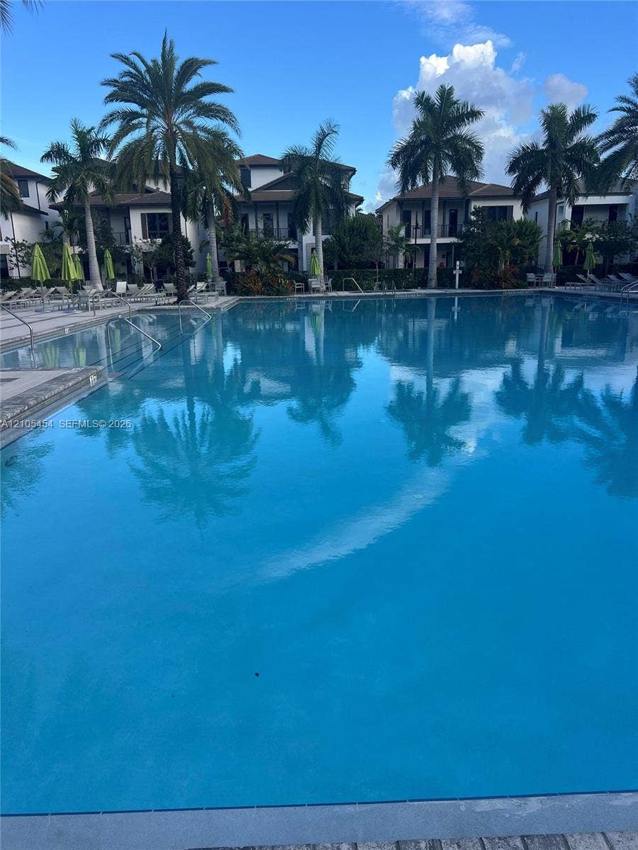 4745 NW 84th Court, #20, Doral, FL 33166 Resort-style swimming pool bordered by residences with balconies and mature palm trees