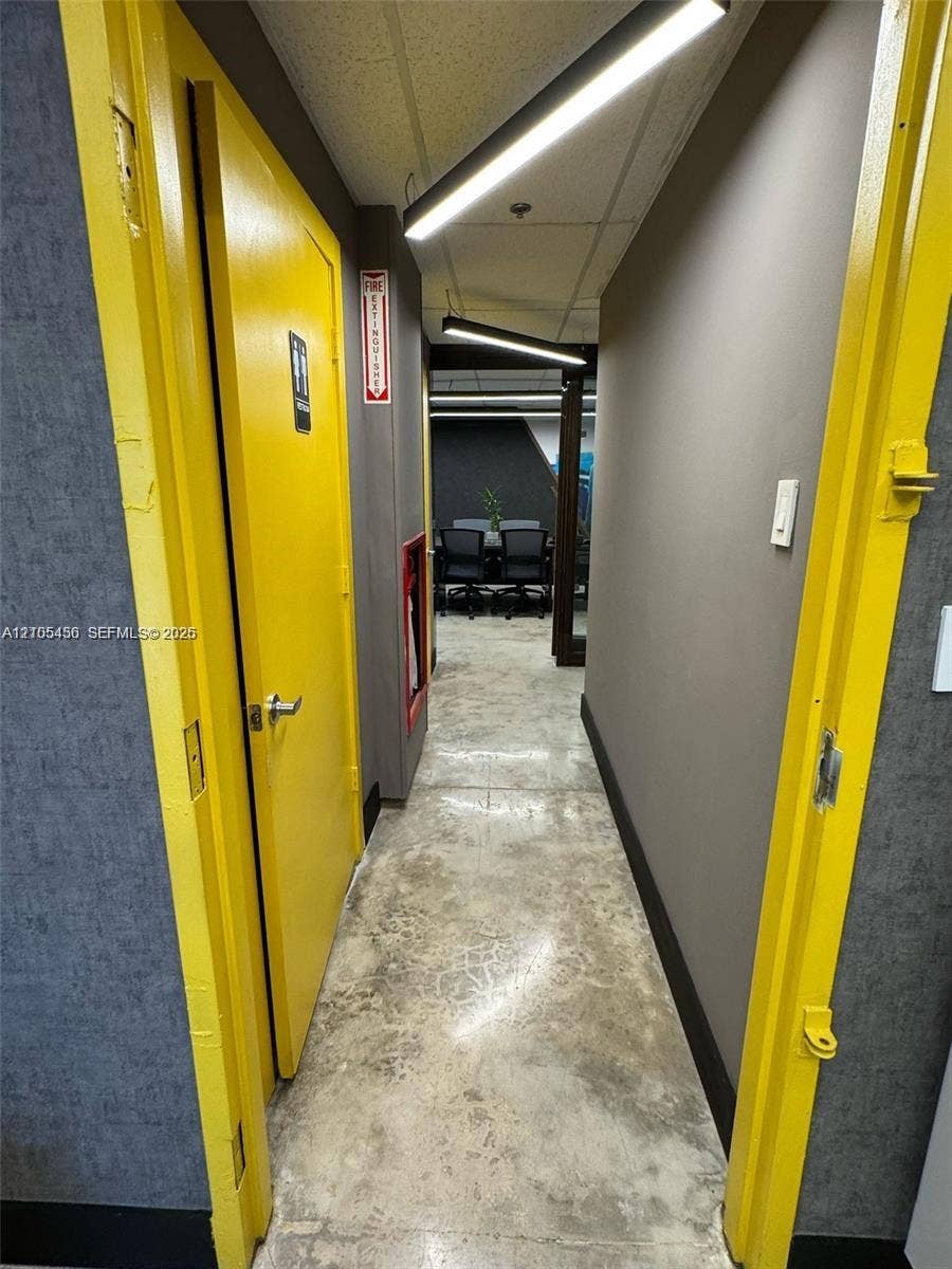 Polished concrete flooring, recessed lighting, and bright yellow door frames