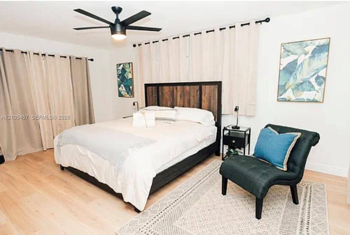 1083 SW 25th Avenue, Boynton Beach, FL 33426 Light-toned wood-finish flooring and matte black ceiling fan with integrated lighting