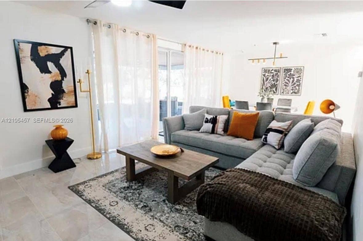 1083 SW 25th Avenue, Boynton Beach, FL 33426 Large-format tile flooring, sliding glass doors, and linear multi-bulb chandelier