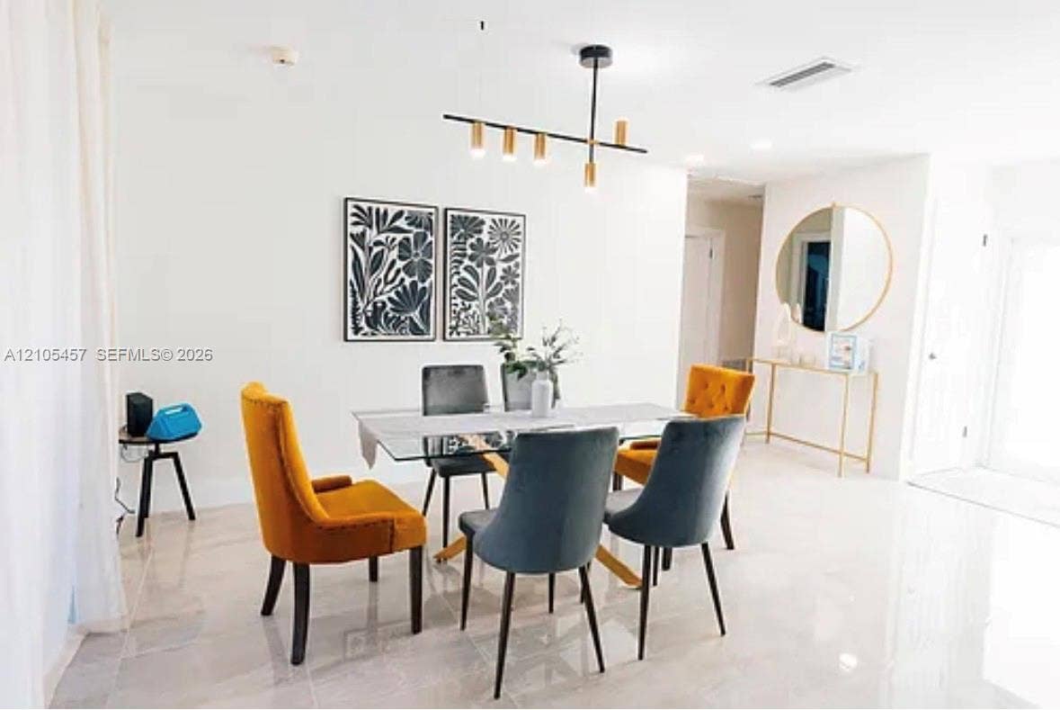 1083 SW 25th Avenue, Boynton Beach, FL 33426 Neutral-toned large-format tile flooring, contemporary matte black linear chandelier with gold accents, and recessed ceiling lighting