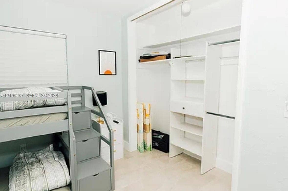 1083 SW 25th Avenue, Boynton Beach, FL 33426 Built-in closet featuring white shelving, hanging rods, and an overhead storage compartment