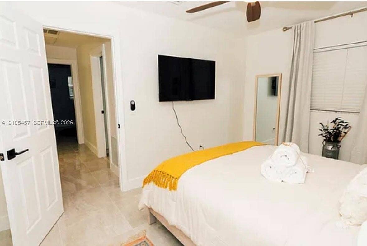 1083 SW 25th Avenue, Boynton Beach, FL 33426 Neutral-toned tile flooring, solid-core interior doors with matte black hardware, and a ceiling fan with integrated lighting
