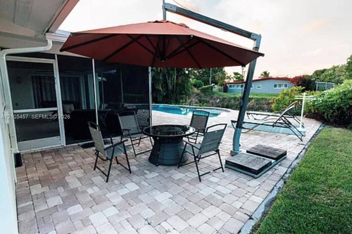 1083 SW 25th Avenue, Boynton Beach, FL 33426 Paver patio featuring a screen-enclosed porch and a concrete swimming pool