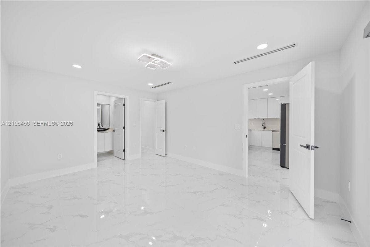 White tile flooring, recessed lighting, modern ceiling light fixture, white walls, white interior doors