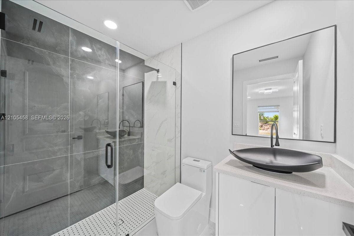 Glass-enclosed shower with large format tile surround