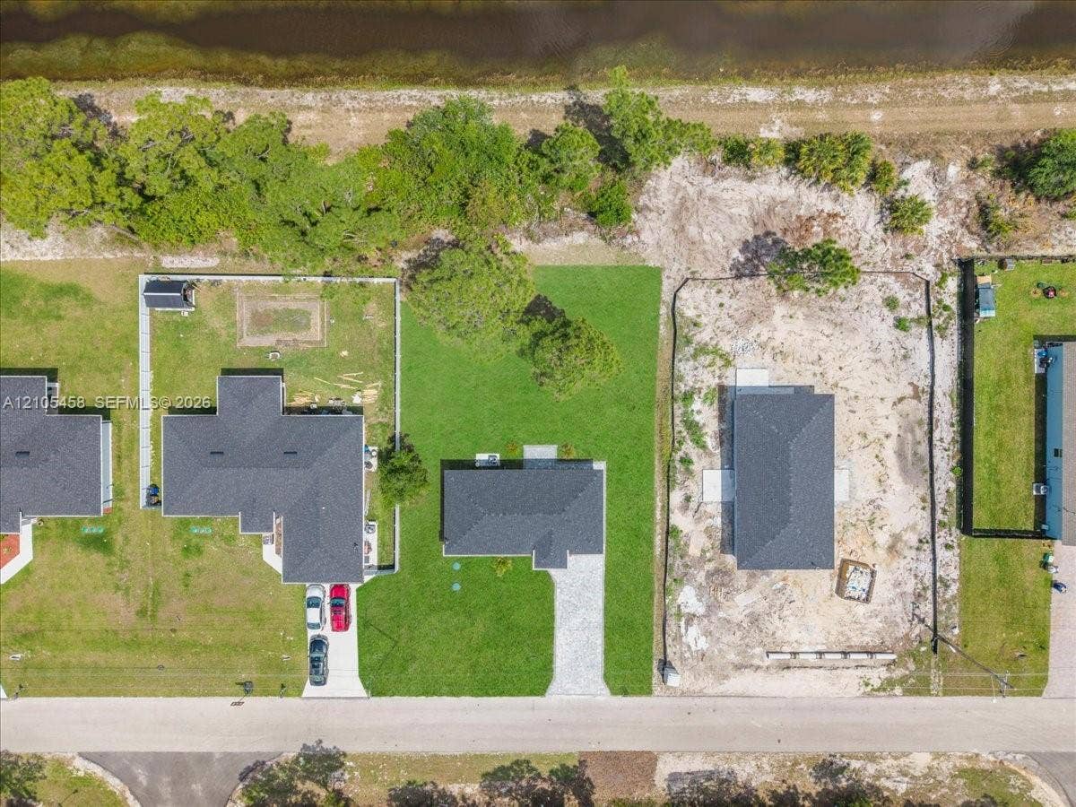 Spacious lot featuring a partial structure, surrounded by undeveloped land and a water body