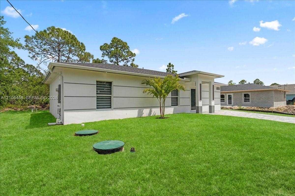 Modern exterior with white siding, dark gray accents, and a covered entry