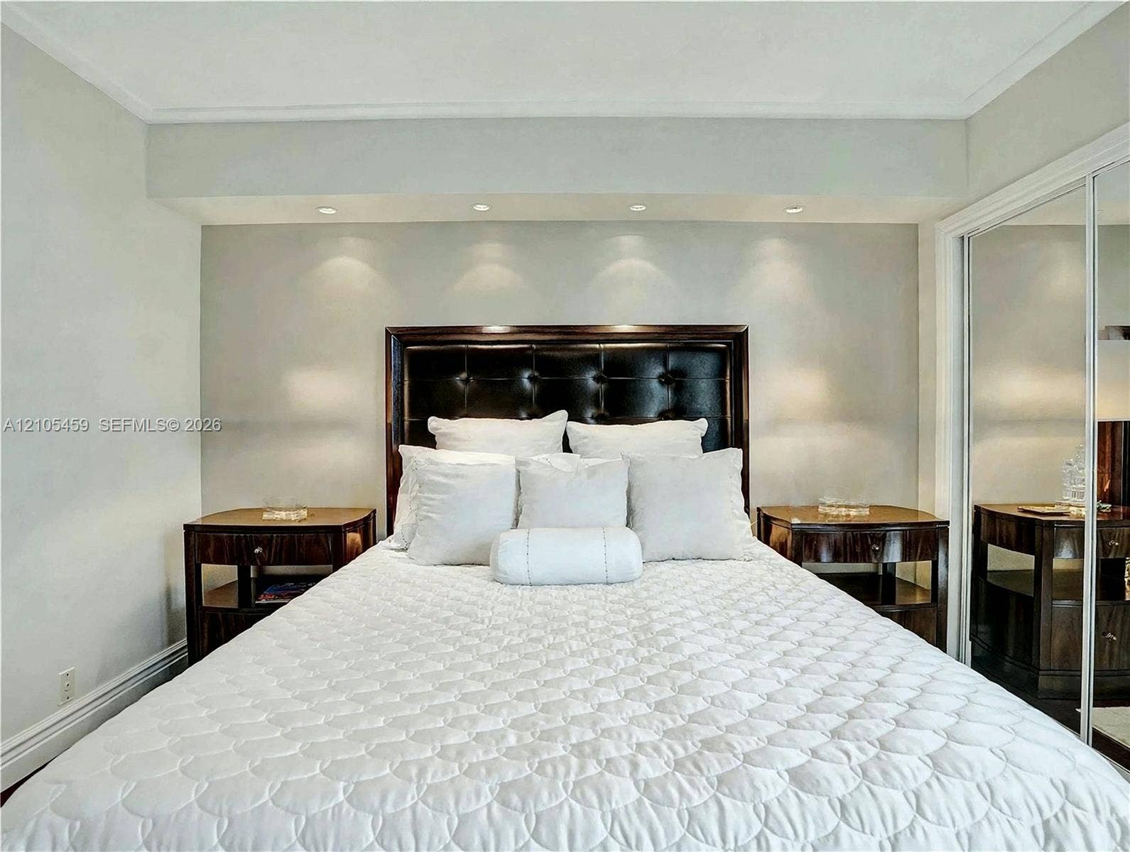 Recessed lighting, crown molding, wood-finish flooring, mirrored closet doors, and a built-in headboard