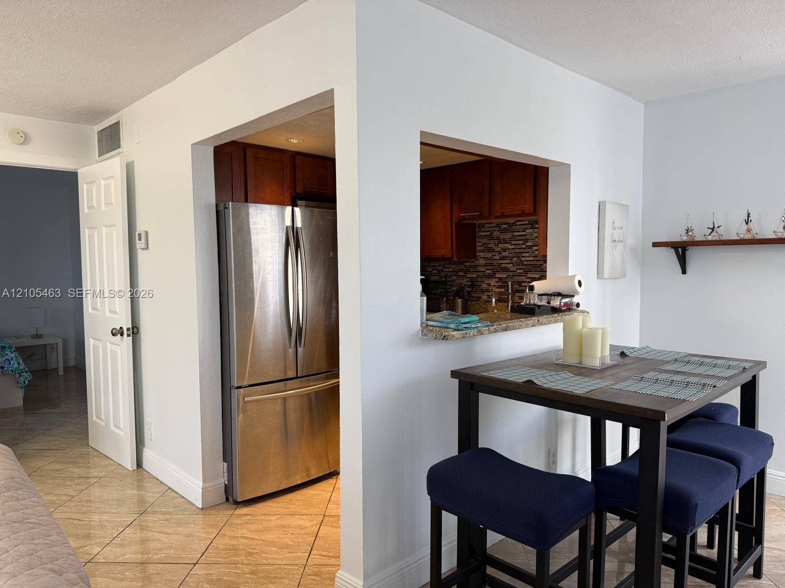 Kitchen pass-through with granite-style countertop and tile backsplash