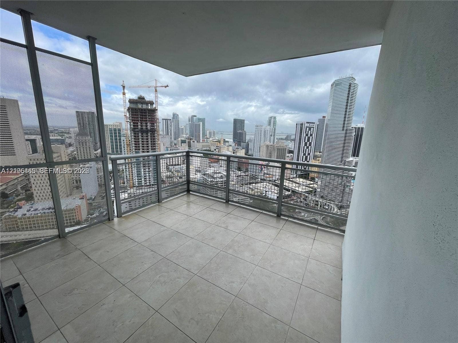 Outdoor balcony featuring tile flooring and a metal railing