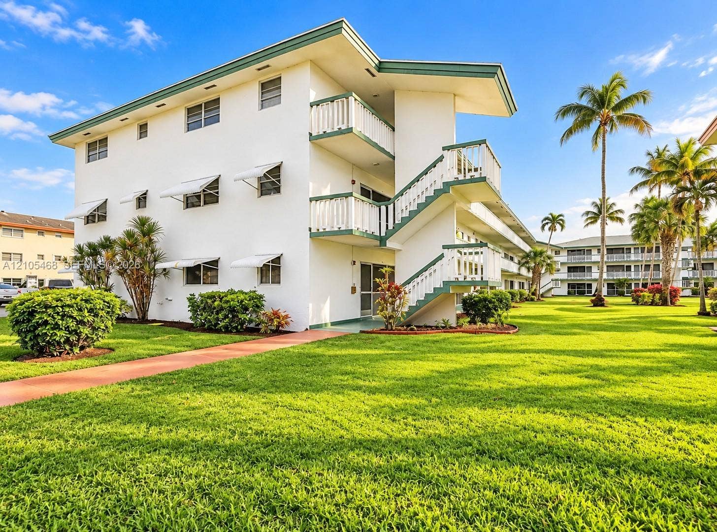 5300 Washington Street, #I201, Hollywood, FL 33021 Multi-story building featuring white exterior, green trim, and white awnings