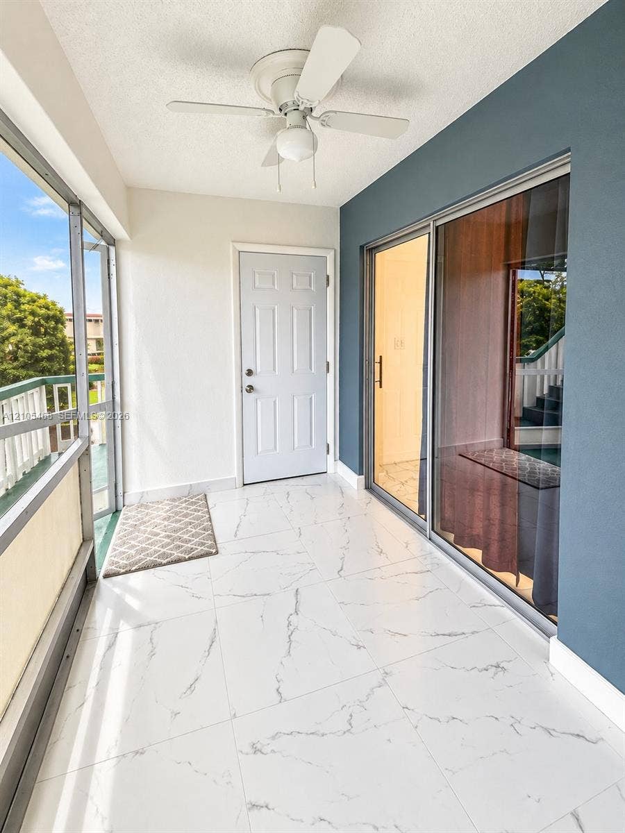 5300 Washington Street, #I201, Hollywood, FL 33021 Enclosed balcony with white tile flooring, ceiling fan, and sliding glass door