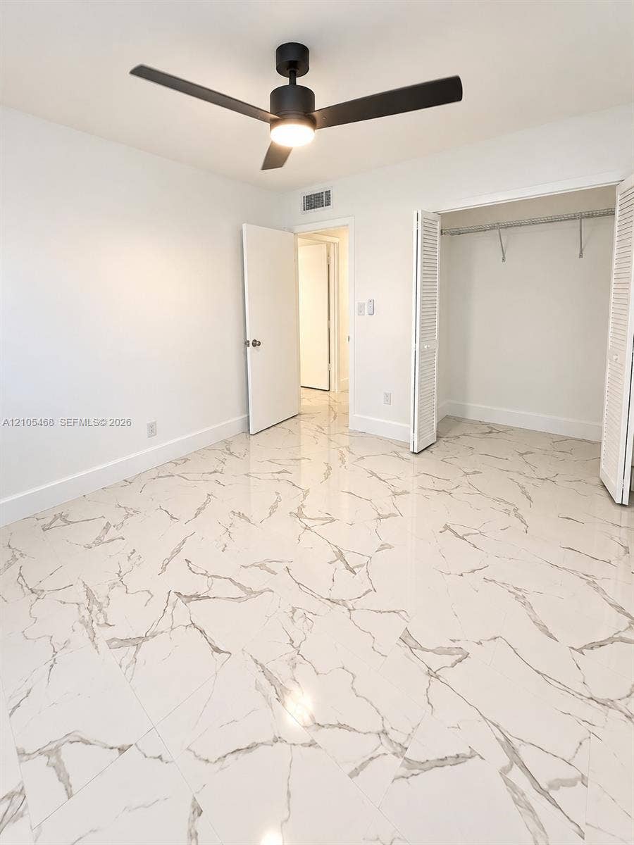 5300 Washington Street, #I201, Hollywood, FL 33021 White walls with a black ceiling fan, featuring a bifold closet and large format tile flooring