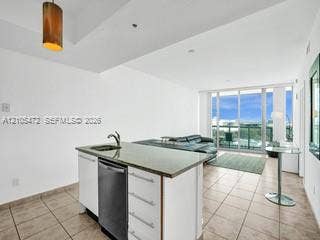 888 Biscayne Boulevard, #811, Miami, FL 33132 Kitchen island with an undermount sink and integrated dishwasher, tile flooring, and floor-to-ceiling sliding glass doors