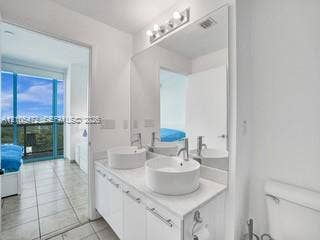 888 Biscayne Boulevard, #811, Miami, FL 33132 Double vanity with vessel sinks, white cabinetry, and a large wall-mounted mirror