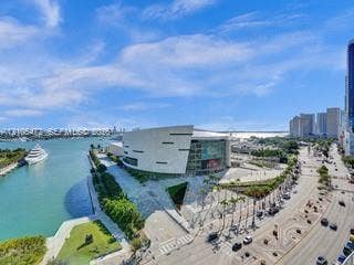 888 Biscayne Boulevard, #811, Miami, FL 33132 Expansive cityscape with prominent waterway, a large white vessel, and a modern architectural structure