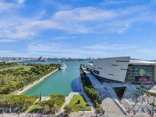 888 Biscayne Boulevard, #811, Miami, FL 33132 Waterfront setting featuring a modern structure, green spaces, and a prominent bridge