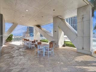 888 Biscayne Boulevard, #811, Miami, FL 33132 Spacious outdoor patio with tiled flooring, structural concrete columns, a glass railing, and distant water scenery