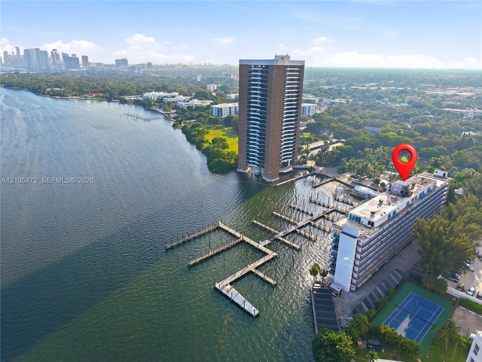 770 NE 69th Street, #6F, Miami, FL 33138 Waterfront property featuring extensive boat slips, a tennis court, and a high-rise building with multiple balconies