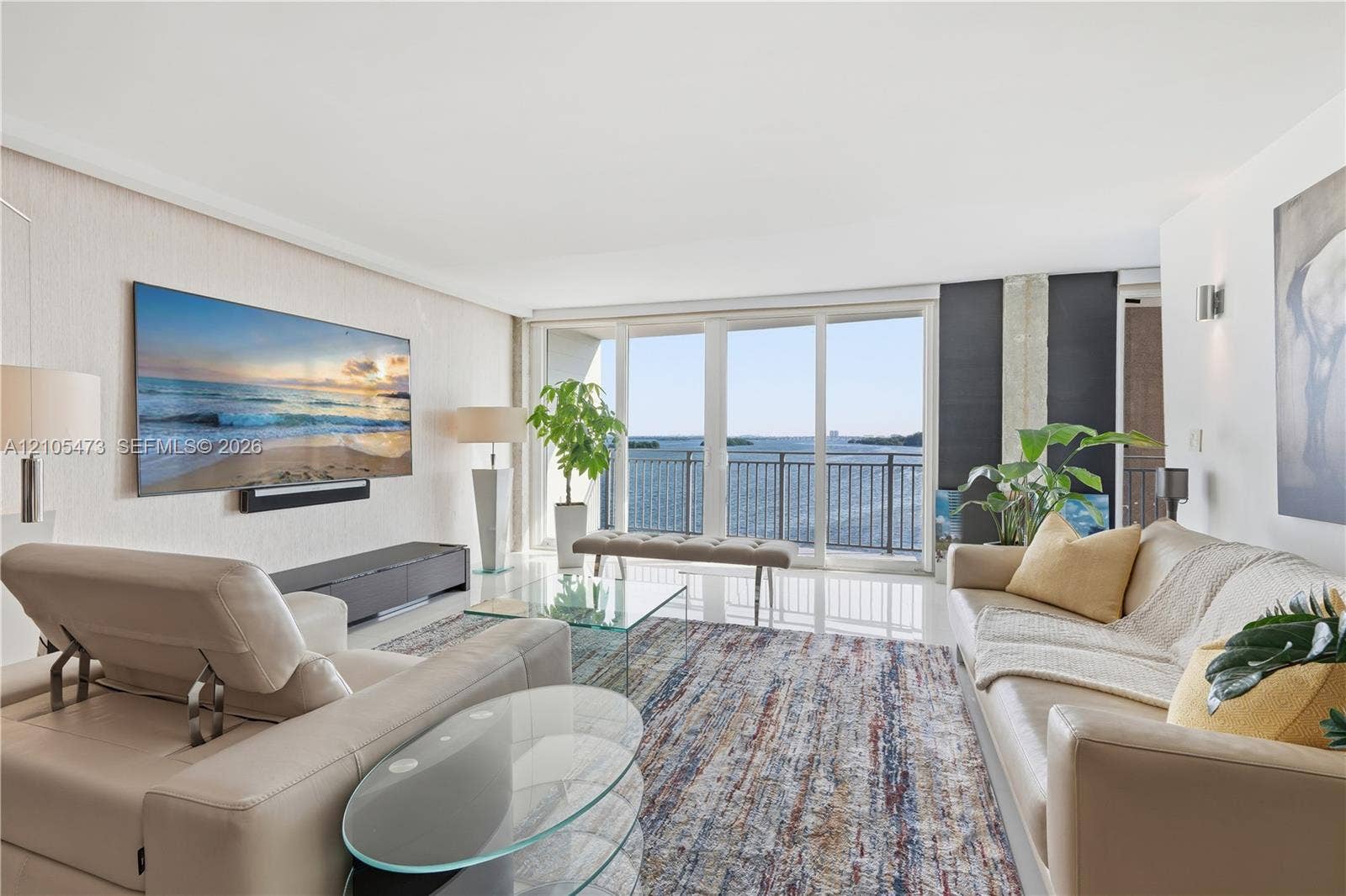 770 NE 69th Street, #6F, Miami, FL 33138 Expansive sliding glass doors, white tile flooring, recessed ceiling lighting, and wall-mounted sconces