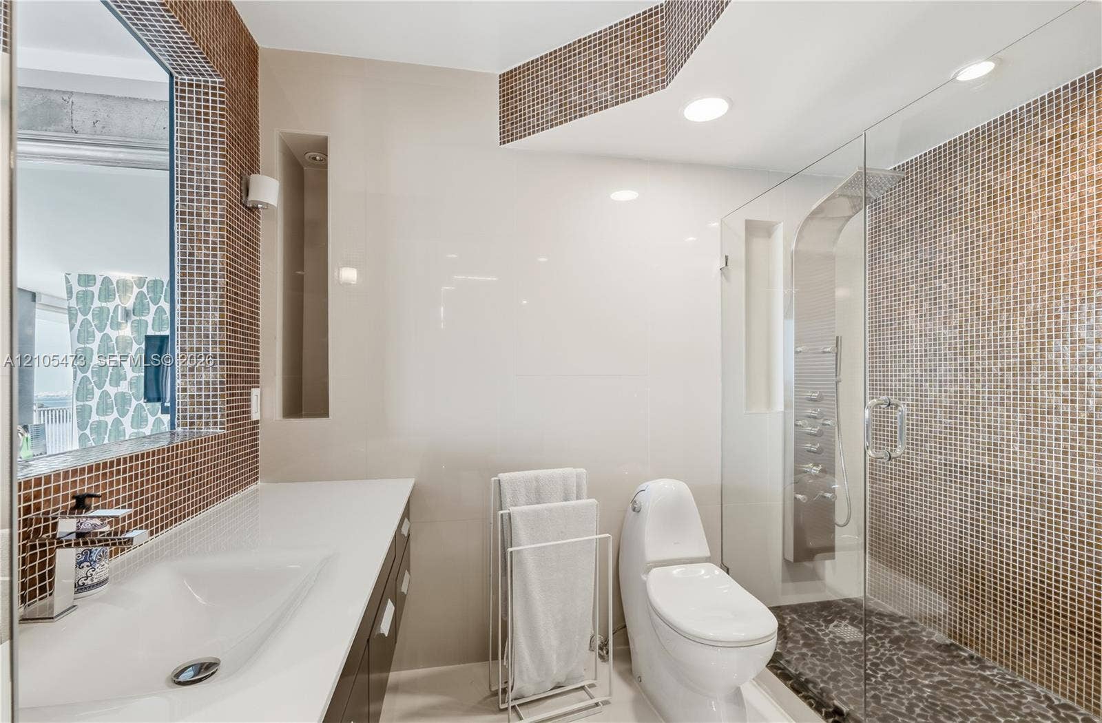 770 NE 69th Street, #6F, Miami, FL 33138 Glass-enclosed shower with pebble-finish flooring and mosaic tile surround