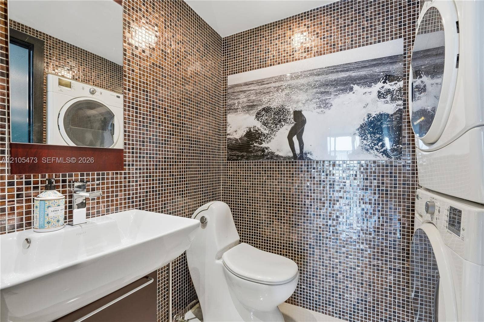770 NE 69th Street, #6F, Miami, FL 33138 Mosaic tiled walls with a white rectangular sink, chrome faucet, and built-in mirror